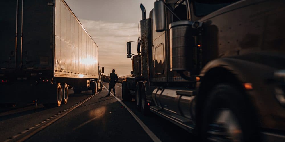 Commercial trucks on a California highway at dusk